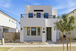 Contemporary home featuring stucco siding and a balcony