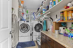 Washroom with independent washer and dryer, a textured ceiling, and light tile patterned floors