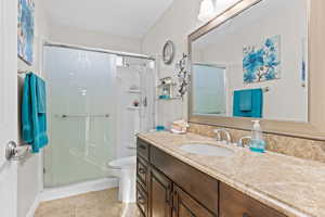 Bathroom with vanity, a stall shower, and tile patterned floors