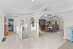 Foyer entrance featuring washer and dryer, recessed lighting, light tile patterned flooring, ceiling fan, and arched walkways