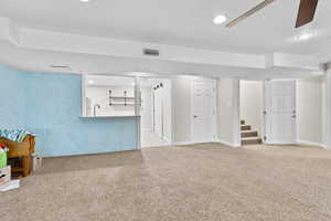Finished basement featuring carpet floors, stairway, a ceiling fan, and recessed lighting