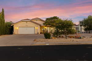 View of front of home with driveway, a garage, stucco siding, and a tile roof