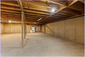 Unfinished basement featuring water heater