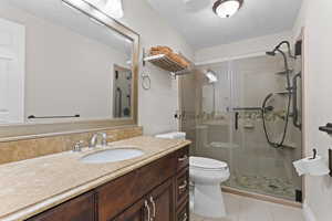 Full bathroom featuring vanity, a stall shower, and tile patterned flooring