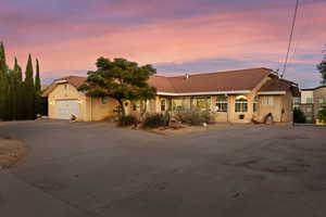 Mediterranean / spanish home featuring a tiled roof, concrete driveway, stucco siding, and an attached garage