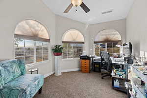 Carpeted office with a ceiling fan and baseboards