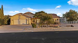 Mediterranean / spanish-style home with a tiled roof, an attached garage, stucco siding, and concrete driveway