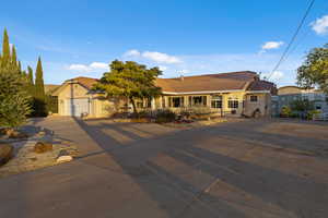 Mediterranean / spanish-style house with driveway, a tile roof, stucco siding, and an attached garage