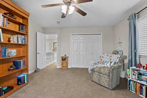 Living area with carpet floors and ceiling fan
