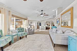 Living room featuring ceiling fan, vaulted ceiling, arched walkways, and recessed lighting