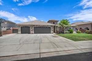 View of front of house featuring a garage, concrete driveway, a tiled roof, stone siding, and stucco siding