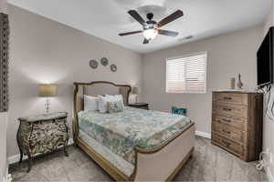 Carpeted bedroom featuring baseboards and ceiling fan