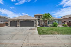 View of front facade featuring driveway, stucco siding, an attached garage, stone siding, and a tiled roof