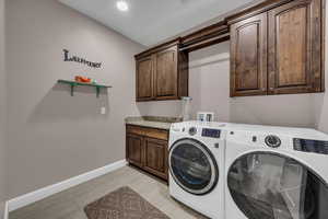 Laundry room featuring separate washer and dryer and cabinet space
