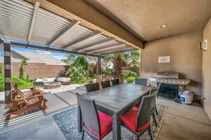 Fenced backyard with a fire pit, a grill, a patio area, and a pergola