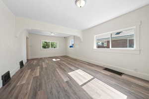 Spare room featuring wood finished floors and arched walkways