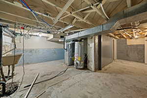 Unfinished below grade area featuring gas water heater and heating unit