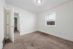 Carpeted spare room with baseboards