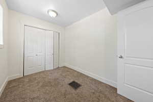 Unfurnished bedroom with carpet flooring and a closet