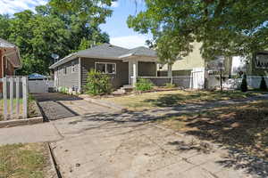 Bungalow with driveway, a gate, a porch, and roof with shingles