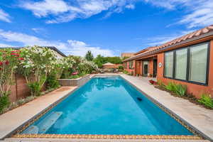 View of swimming pool with a fenced backyard and a patio