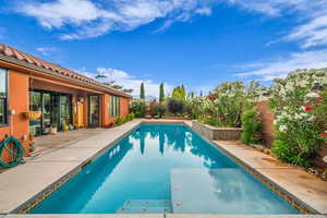 Swimming pool with a patio area and a fenced backyard
