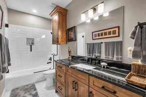 Full bath with vanity, bathtub / shower combination, and tile patterned flooring
