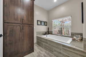 Bathroom featuring a garden tub and recessed lighting