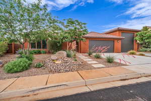View of front of house with an attached garage, concrete driveway, stucco siding, and a tile roof