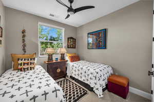 Carpeted bedroom featuring a ceiling fan and baseboards