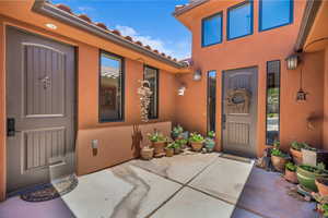 Property entrance with stucco siding and a tiled roof