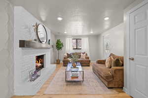 Living area featuring wood finished floors, a fireplace, and recessed lighting