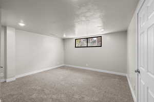 Carpeted spare room with baseboards and recessed lighting