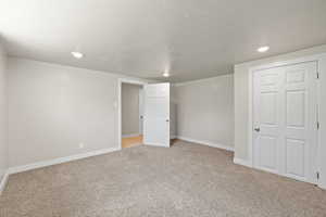 Basement with light carpet and recessed lighting