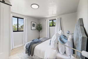 Bedroom with a barn door and wood finished floors