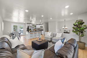 Living area with light wood-style flooring, recessed lighting, and a chandelier