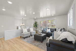 Living area featuring recessed lighting, a chandelier, and wood finished floors