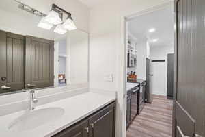 Bathroom with wood finished floors, vanity, and recessed lighting