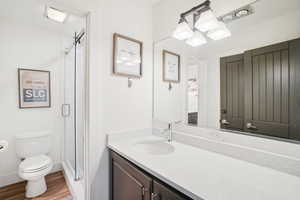 Bathroom featuring vanity, a shower stall, and wood finished floors