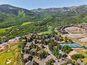 Aerial overview of property's location with a mountainous background and a golf course