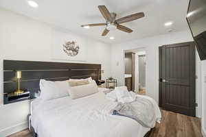 Bedroom featuring wood finished floors, recessed lighting, connected bathroom, and a ceiling fan