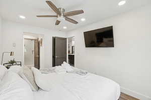 Bedroom featuring wood finished floors, recessed lighting, ceiling fan, and ensuite bathroom