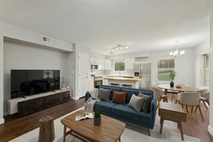 Living area with suspended lighting, dark wood-type flooring, and a textured ceiling