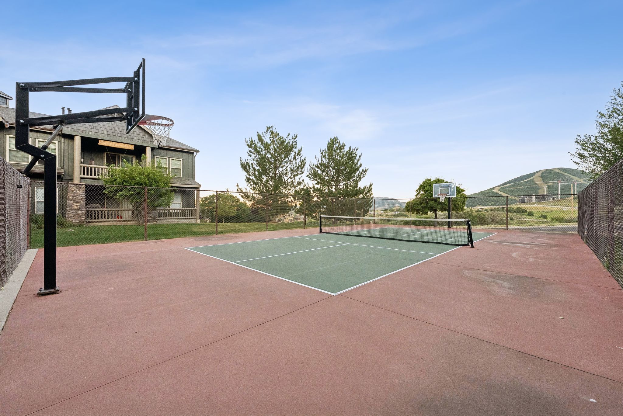 View of tennis court with community basketball court