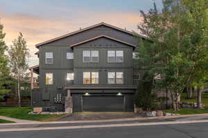 View of front of home featuring asphalt driveway and an attached garage