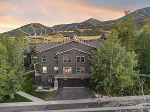 View of front of house featuring a mountain view, board and batten siding, driveway, and an attached garage