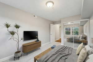Carpeted bedroom with arched walkways, a closet, and a textured ceiling