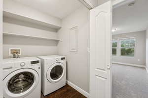 Laundry area featuring washing machine and dryer and baseboards