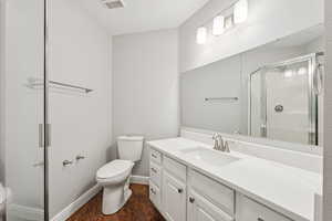 Bathroom with a stall shower, wood finished floors, and vanity