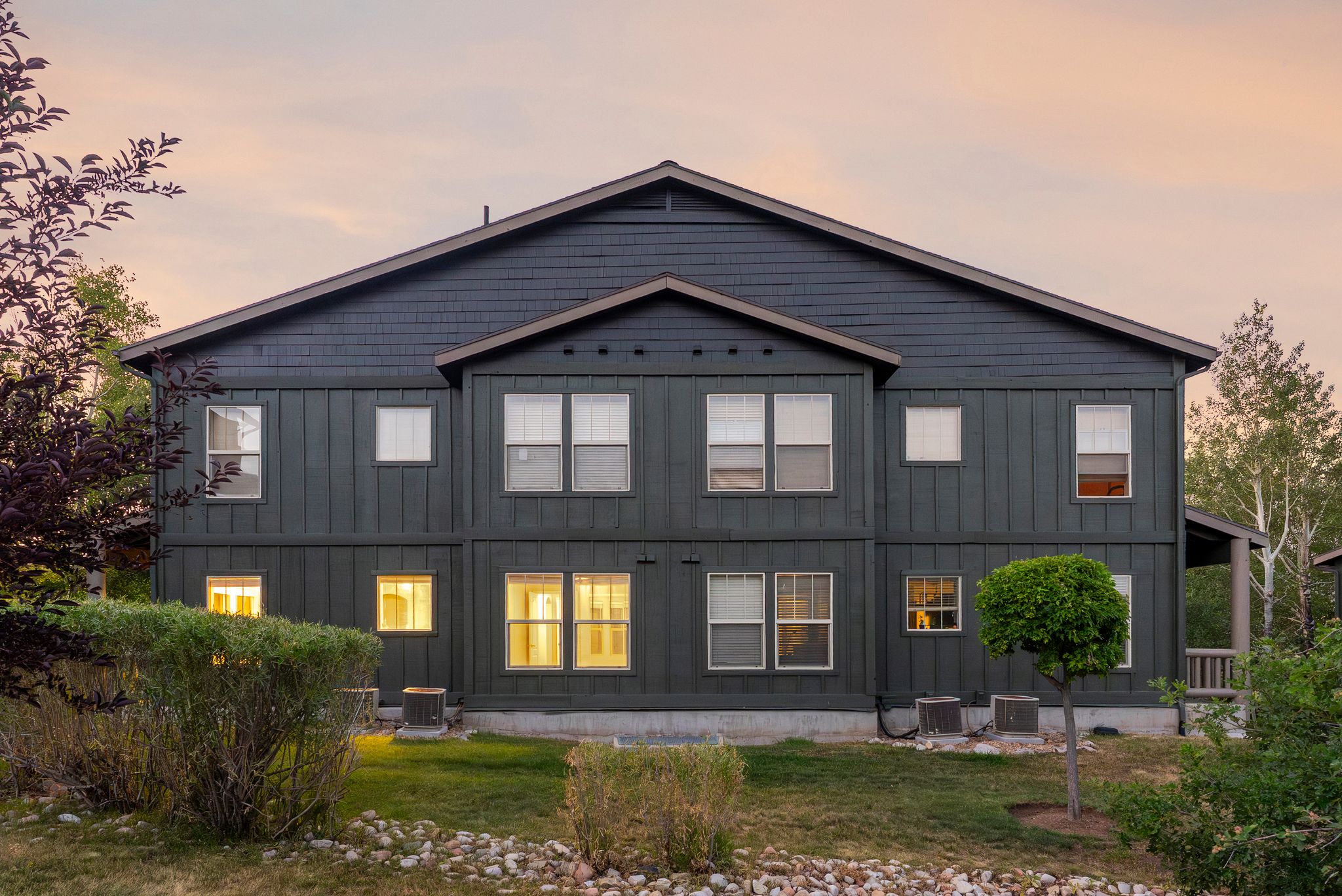 Back of house featuring board and batten siding and a yard